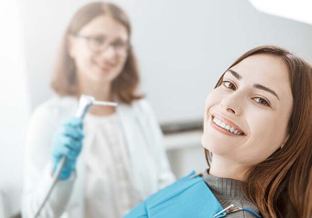 young-woman-sits-dental-chair-smiles-with-white-healthy-teeth